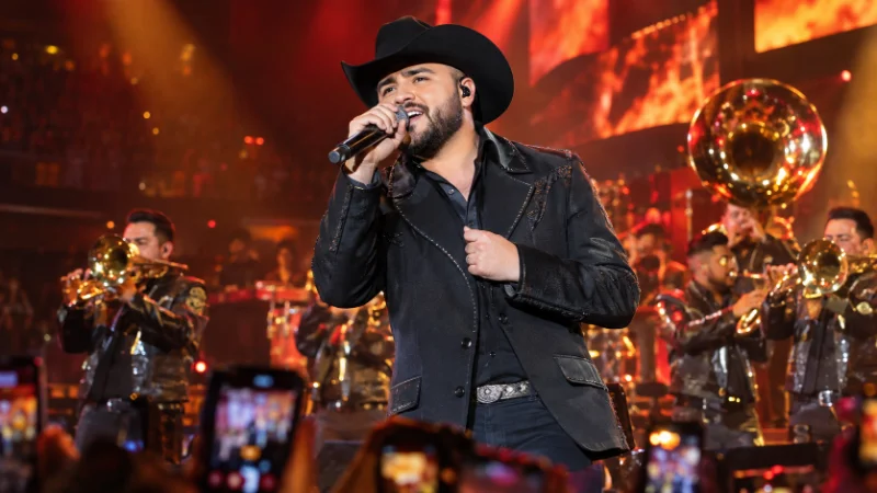 Gerardo Ortiz performing live on stage during a regional Mexican music concert
