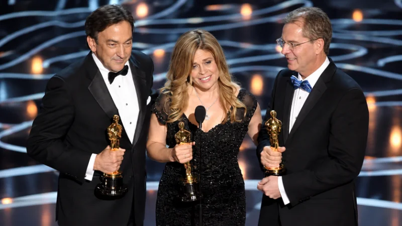 Jennifer Lee holding an award at a film industry ceremony
