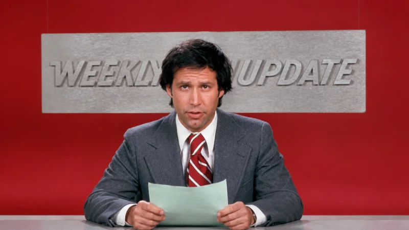 Chevy Chase at a 1970s news desk during his Saturday Night Live years