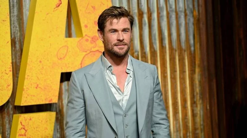 Chris Hemsworth reading a script between takes on an action film set