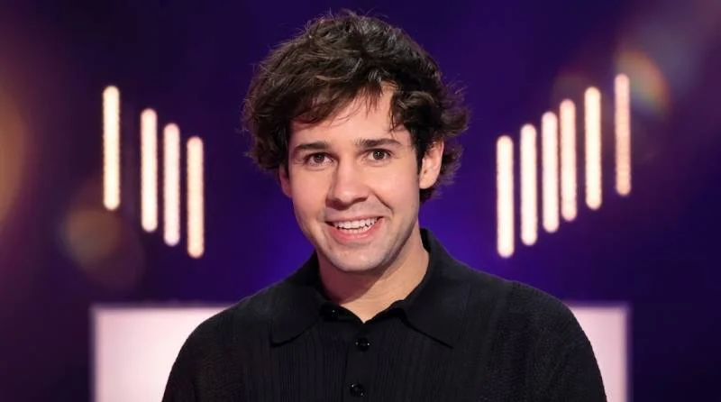 David Dobrik reviewing photos on his phone in a startup office